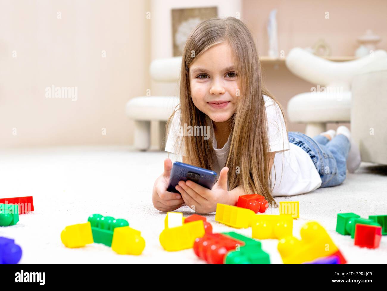 Little girl playing with toys in the children's room Stock Photo - Alamy