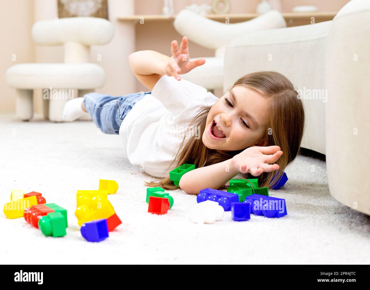 Little girl playing with toys in the children's room Stock Photo - Alamy