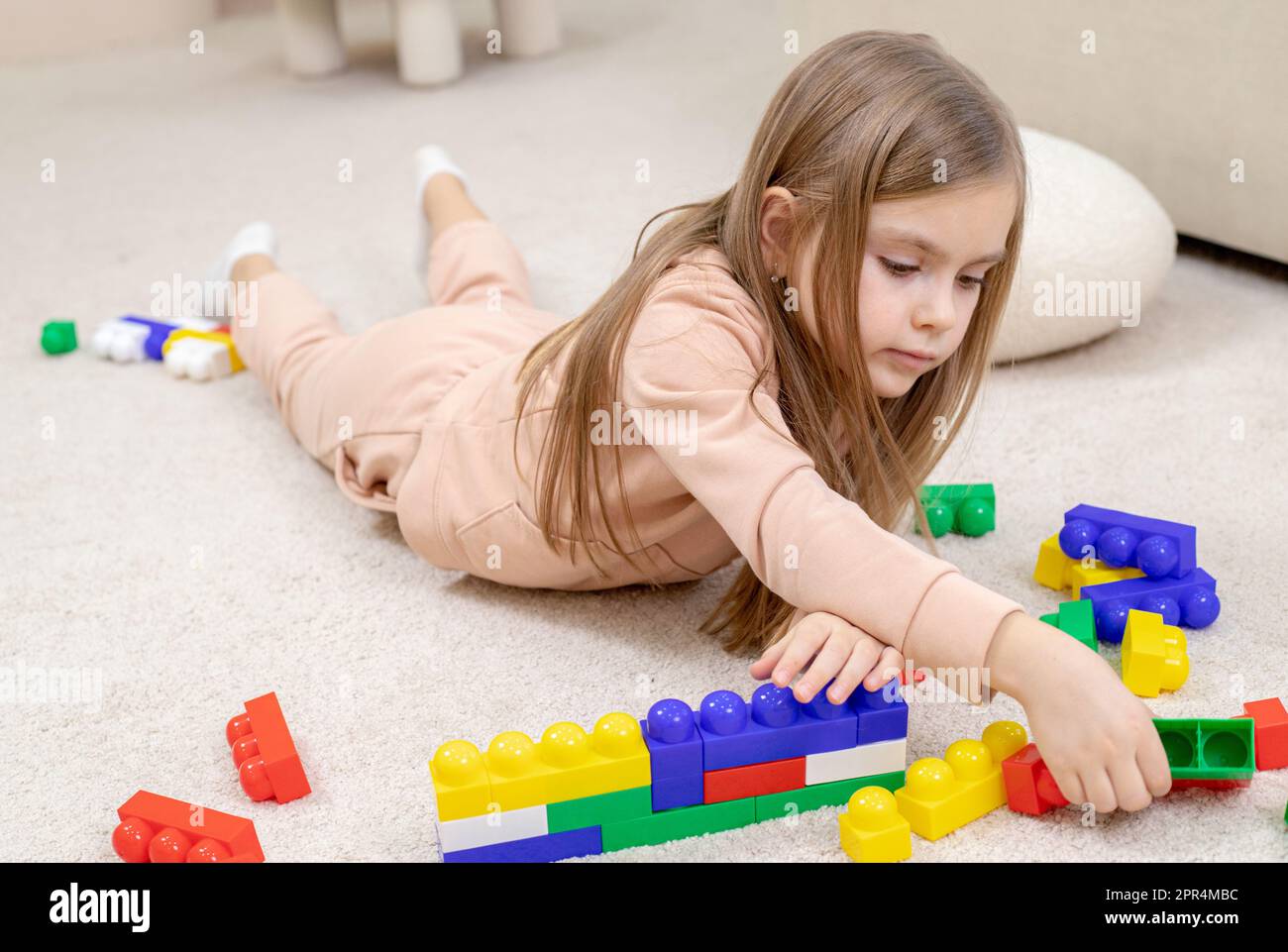 Little girl playing with toys in the children's room Stock Photo - Alamy