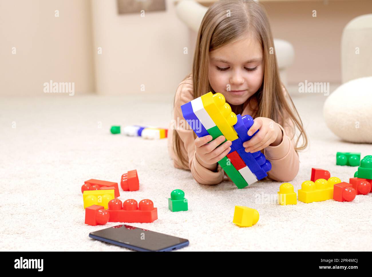 Little girl playing with toys in the children's room Stock Photo - Alamy