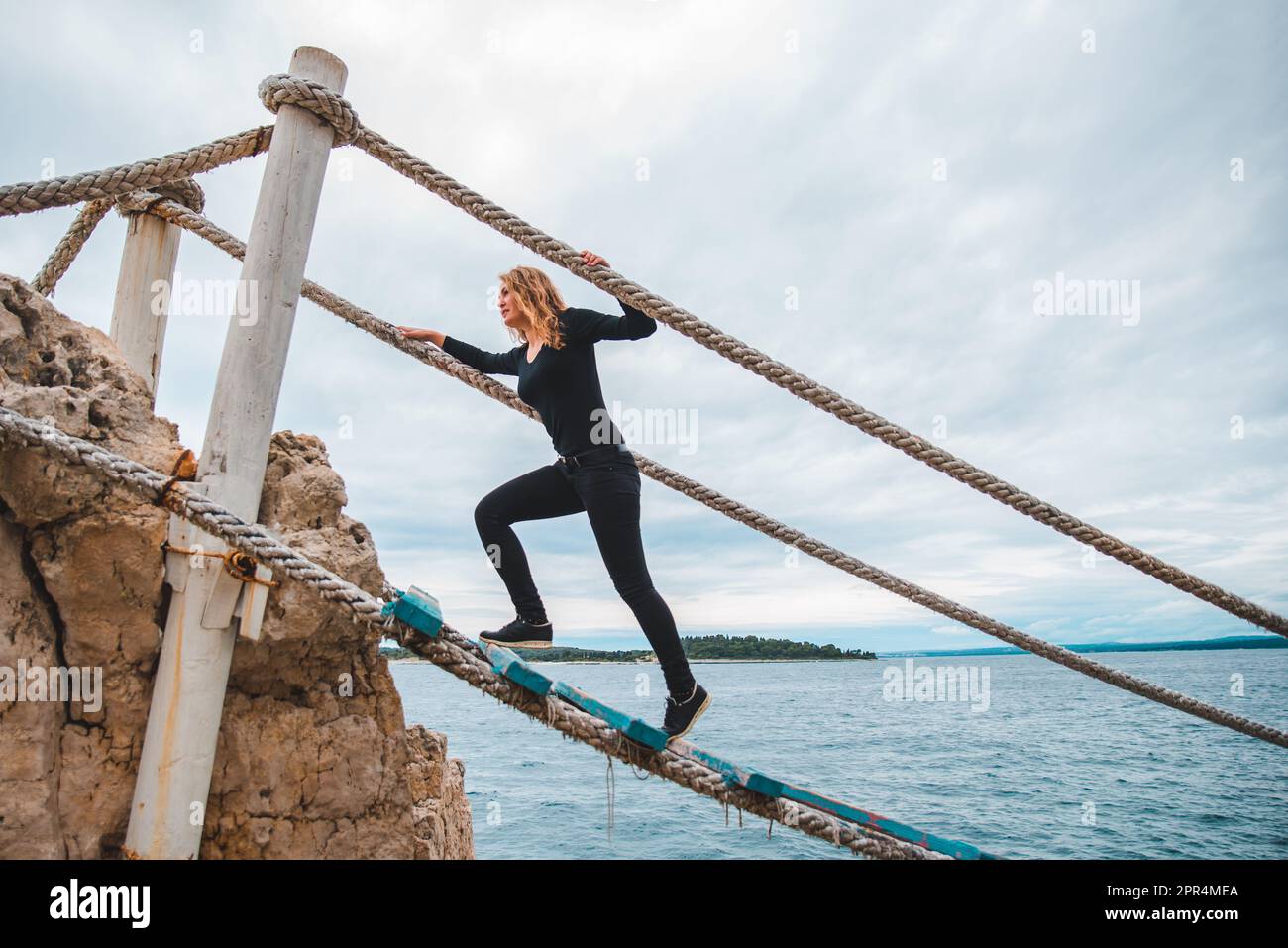Woman Crossing Rope Woman crossing rope bridge hi-res stock photography and images - Alamy