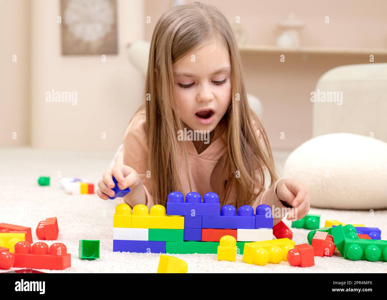 Little girl playing with toys in the children's room Stock Photo - Alamy