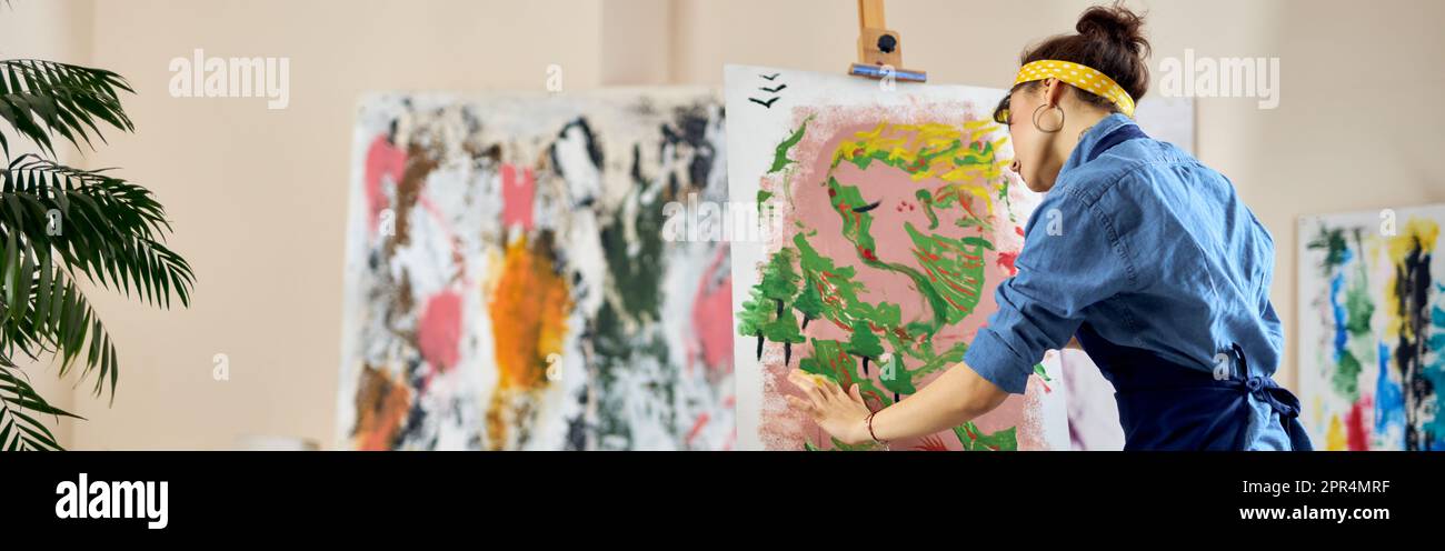Creative woman, female artist in apron looking inspired while creating ...