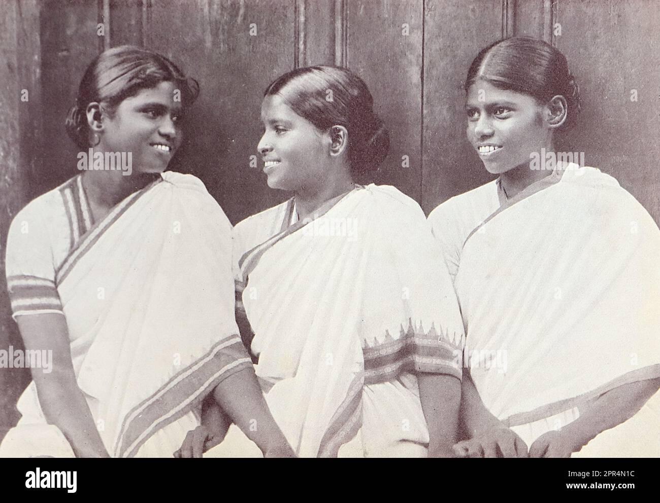 Three convert workers in the Dohnavur compound. Half-tone engraving from a photograph by Mr. Penn of Ootacamund (now known as Ooto), in the Tamil Nadu region of Southern India, c1912. The image relates to the Church of England Zenana Mission’s nursery and compound in Dohnavur, also in Tamil Nadu and about thirty miles from the southern tip of India. The compound was run by Amy Wilson-Carmichael and sought to promote Christianity among babies and children (at the time only girls, many who were victims of temple prostitution). Stock Photo