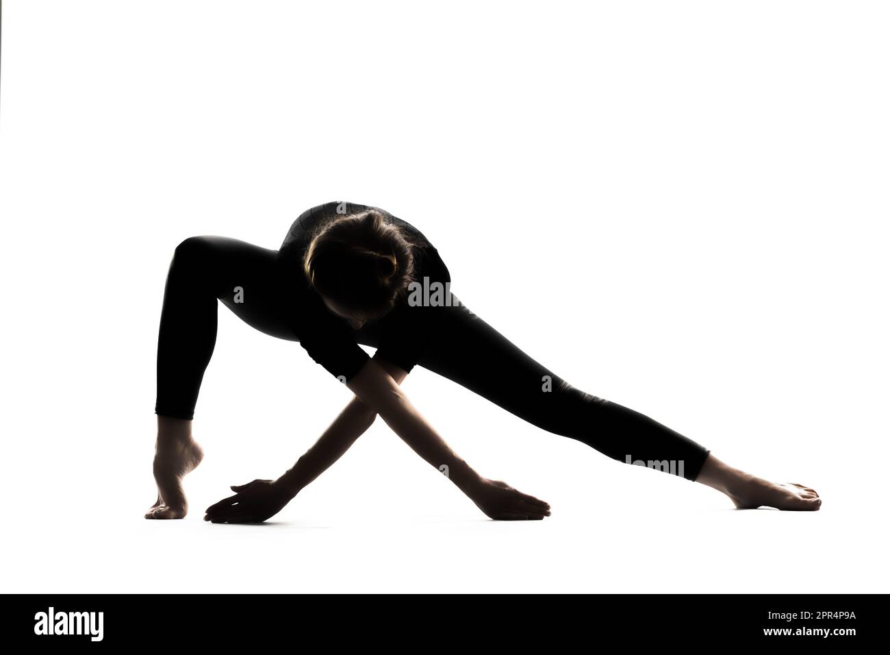 A woman in a yoga asana pose with her arms extended on a white background Stock Photo