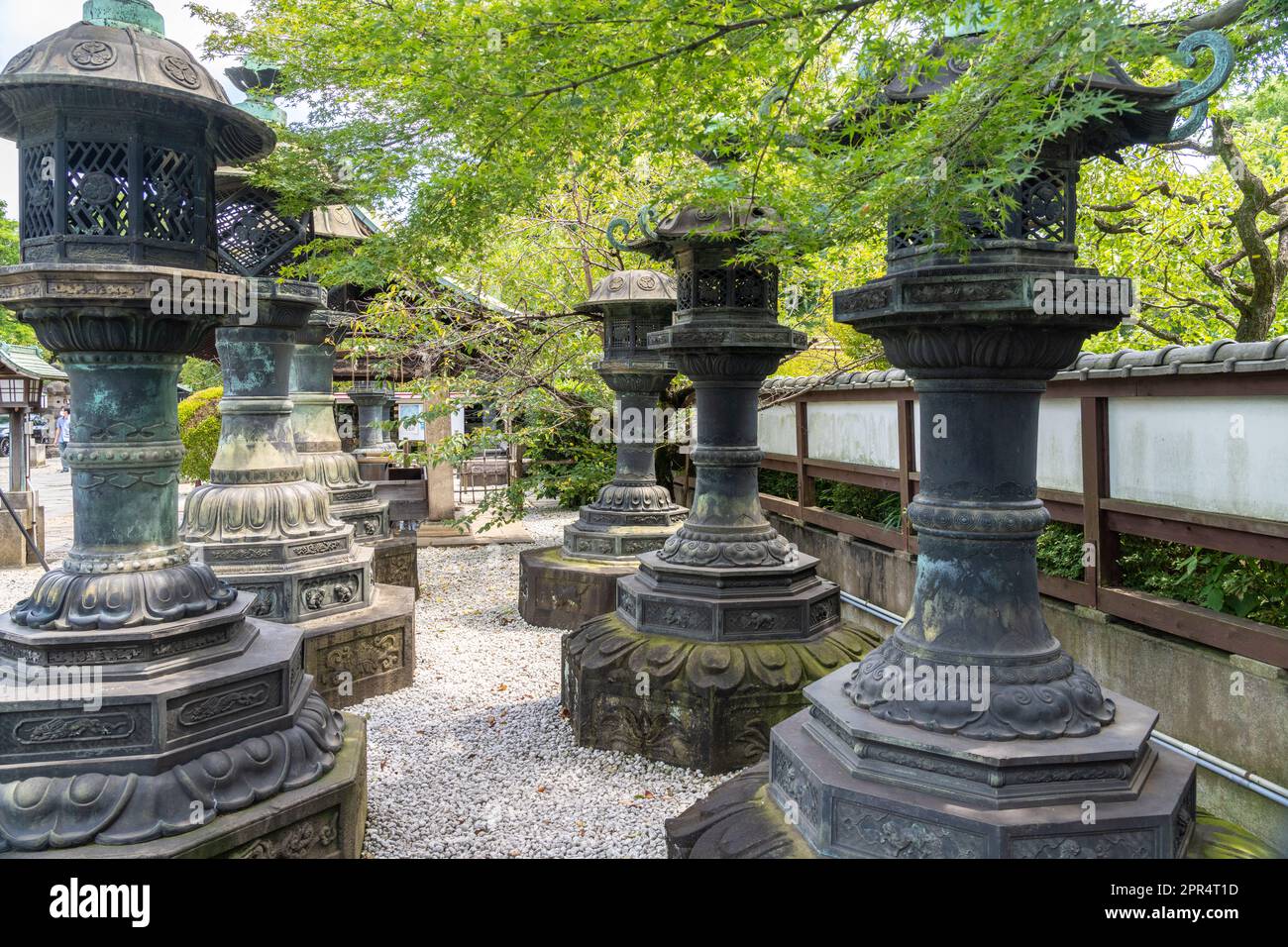 Japanese style stone and cooper lanterns leading to the Ueno Tosho-gu Shrine honden and Karamon in Ueno Park, Tokyo, Japan. The shrine was constructed in 1627 as a mausoleum to the Tokugawa shoguns. Stock Photo