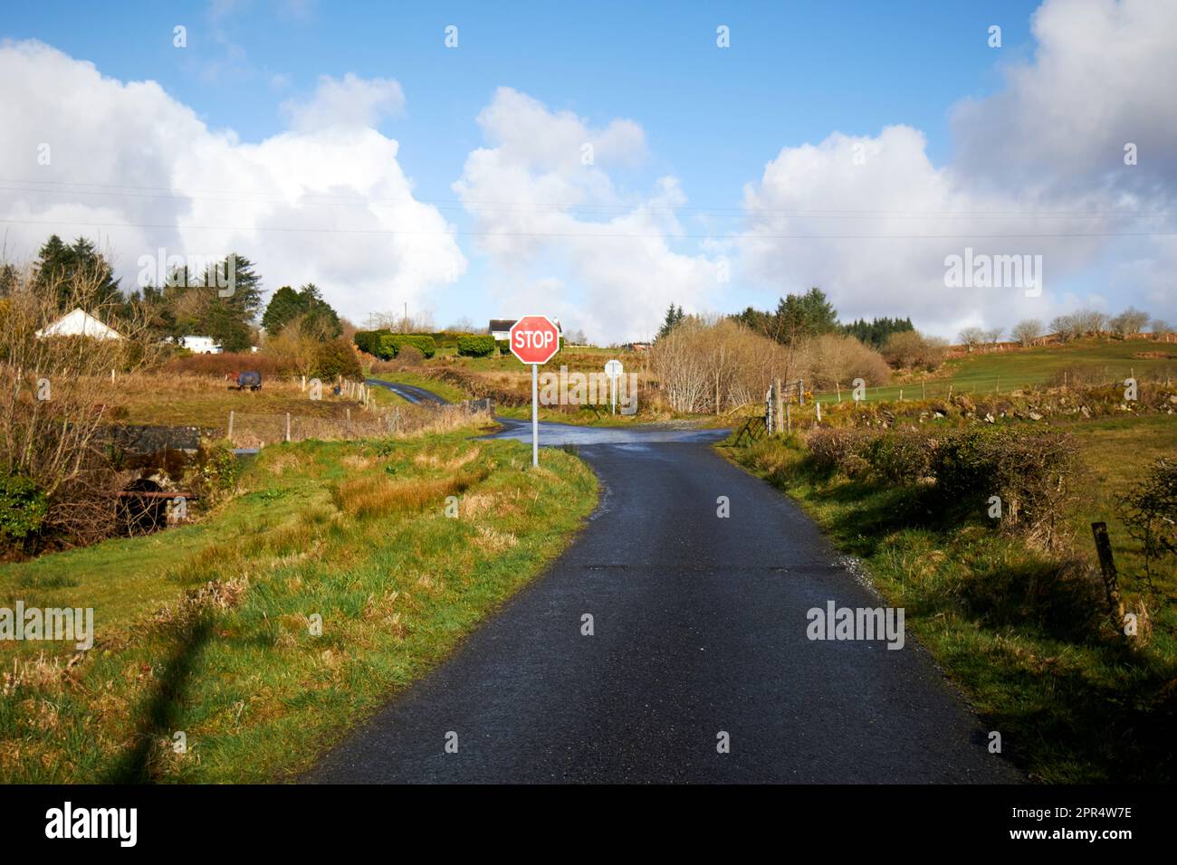long single track road approaching stop sign junction county donegal republic of ireland Stock Photo