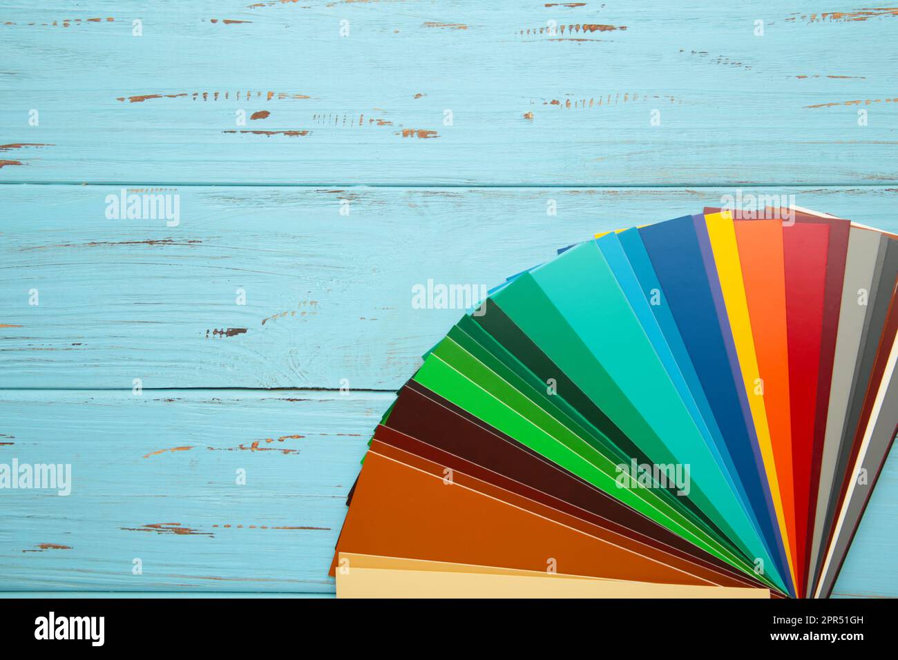 Colored cardboard palette, paper catalog on a blue background. Top view
