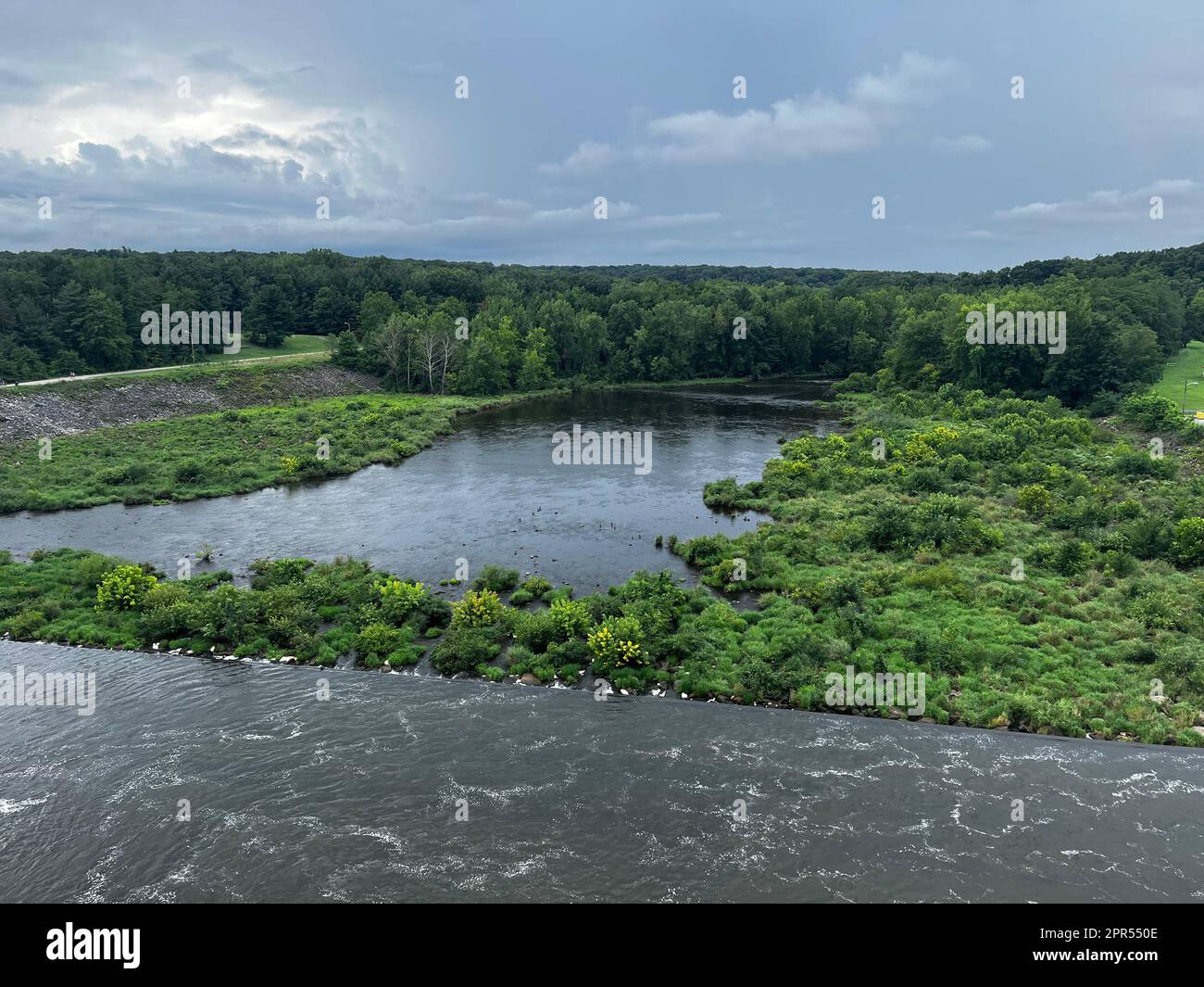 A scenic river surrounded by lush green vegetation and a tranquil body ...