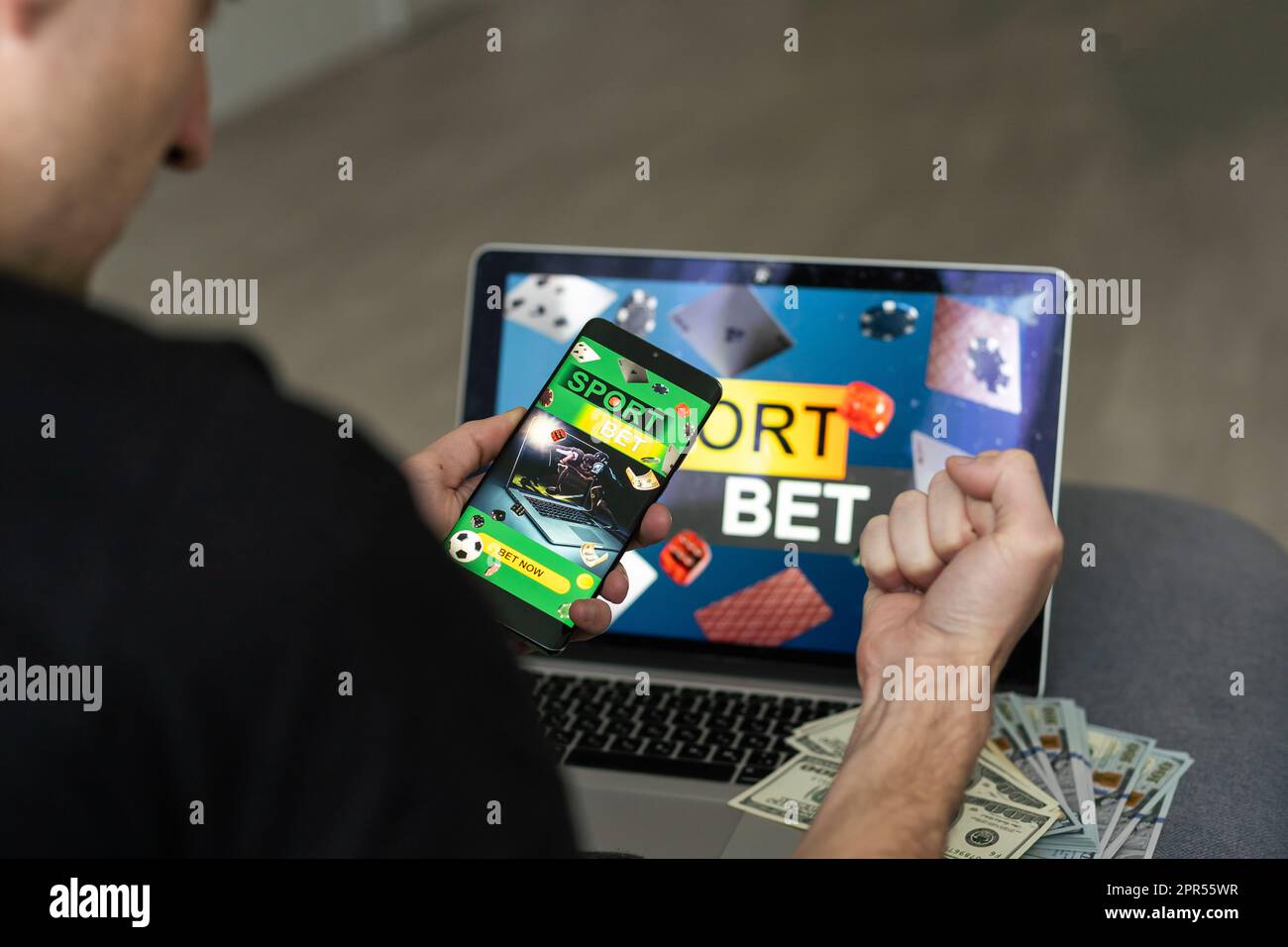 Man watching football play online broadcast on his laptop, cheering for his favourite team, making bets at bookmakers website Stock Photo