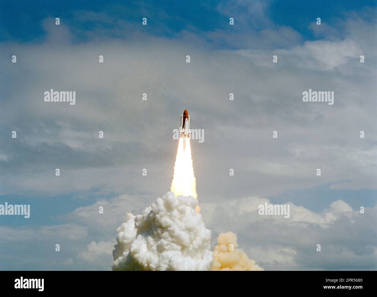 STS-26 Discovery, Orbiter Vehicle (OV) 103, rises into a cloudy sky and heads for Earth orbit atop the external tank (ET) as exhaust plumes billow from the two solid rocket boosters (SRBs) during liftoff from Kennedy Space Center (KSC) Launch Complex (LC) pad 39B. STS-26 marks OV-103's first flight since September 1985 and NASA's first manned mission since 51L Challenger accident, on January 28, 1986. Stock Photo