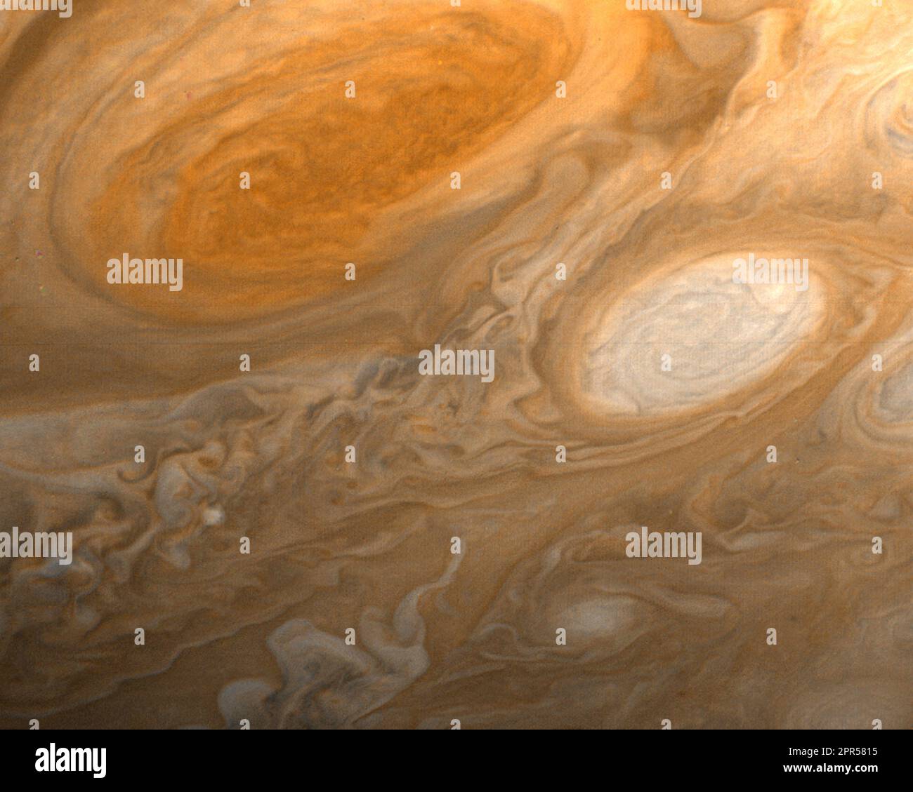 As Voyager 1 flew by Jupiter, it captured this photo of the Great Red Spot. The Great Red Spot is an anti-cyclonic (high- pressure) storm on Jupiter that can be likened to the worst hurricanes on Earth. An ancient storm, it is so large that three Earths could fit inside it. This photo, and others of Jupiter, allowed scientists to see different colors in clouds around the Great Red Spot which imply that the clouds swirl around the spot (going counter-clockwise) at varying altitudes. The Great Red Spot had been observed from Earth for hundreds of years, yet never before with this clarity and clo Stock Photo