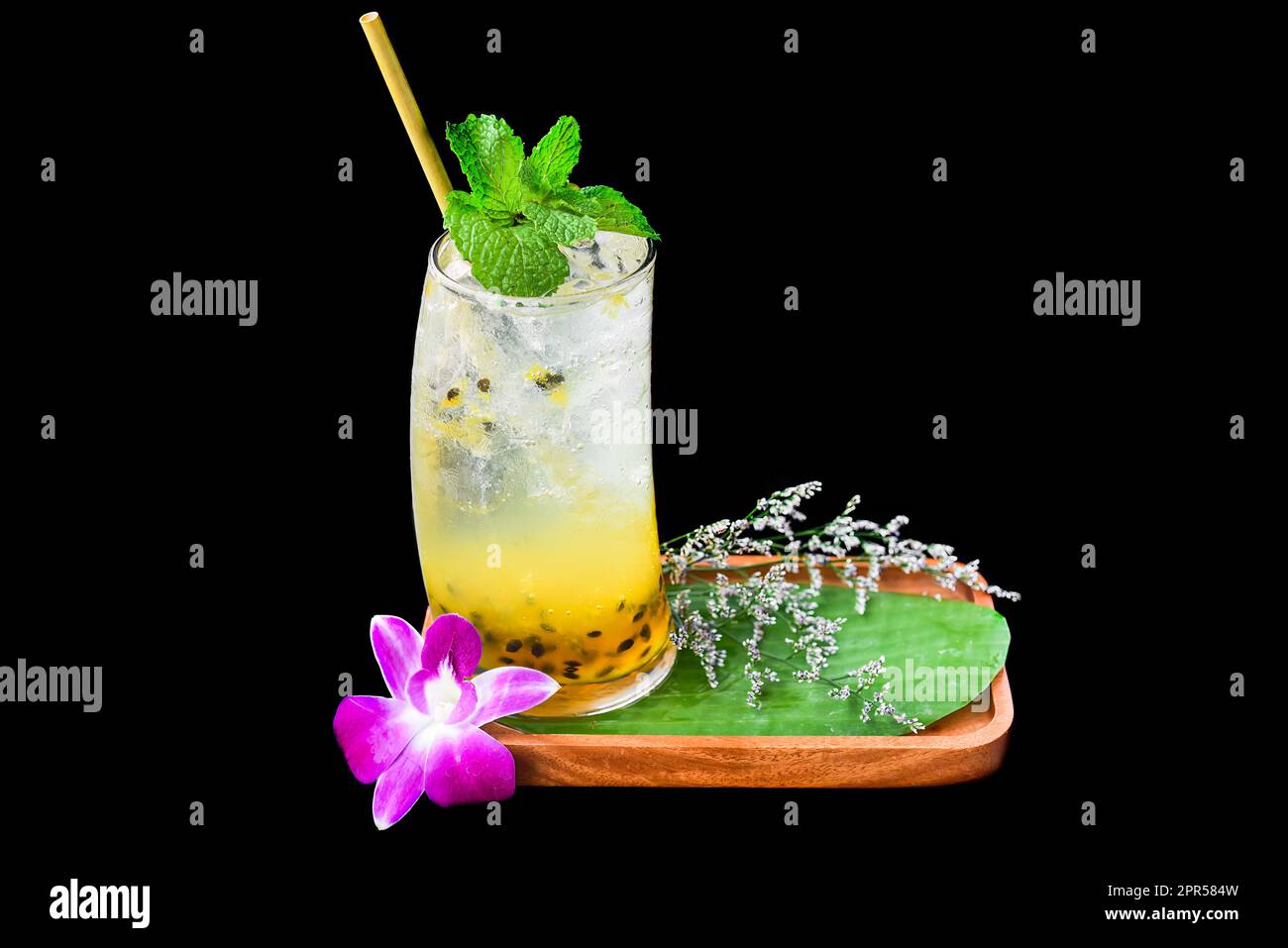 Passion fruit juice with soda and flowers isolated on black background Stock Photo