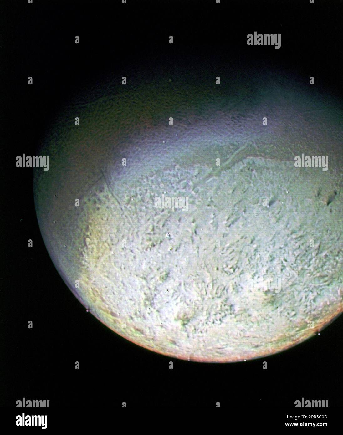 This color photo of Neptune's large satellite Triton was obtained on Aug. 24 1989 at a range of 530,000 kilometers (330,000 miles). The resolution is about 10 kilometers (6.2 miles), sufficient to begin to show topographic detail. The image was made from pictures taken through the green, violet and ultraviolet filters. In this technique, regions that are highly reflective in the ultraviolet appear blue in color. In reality, there is no part of Triton that would appear blue to the eye. The bright southern hemisphere of Triton, which fills most of this frame, is generally pink in tone as is the Stock Photo