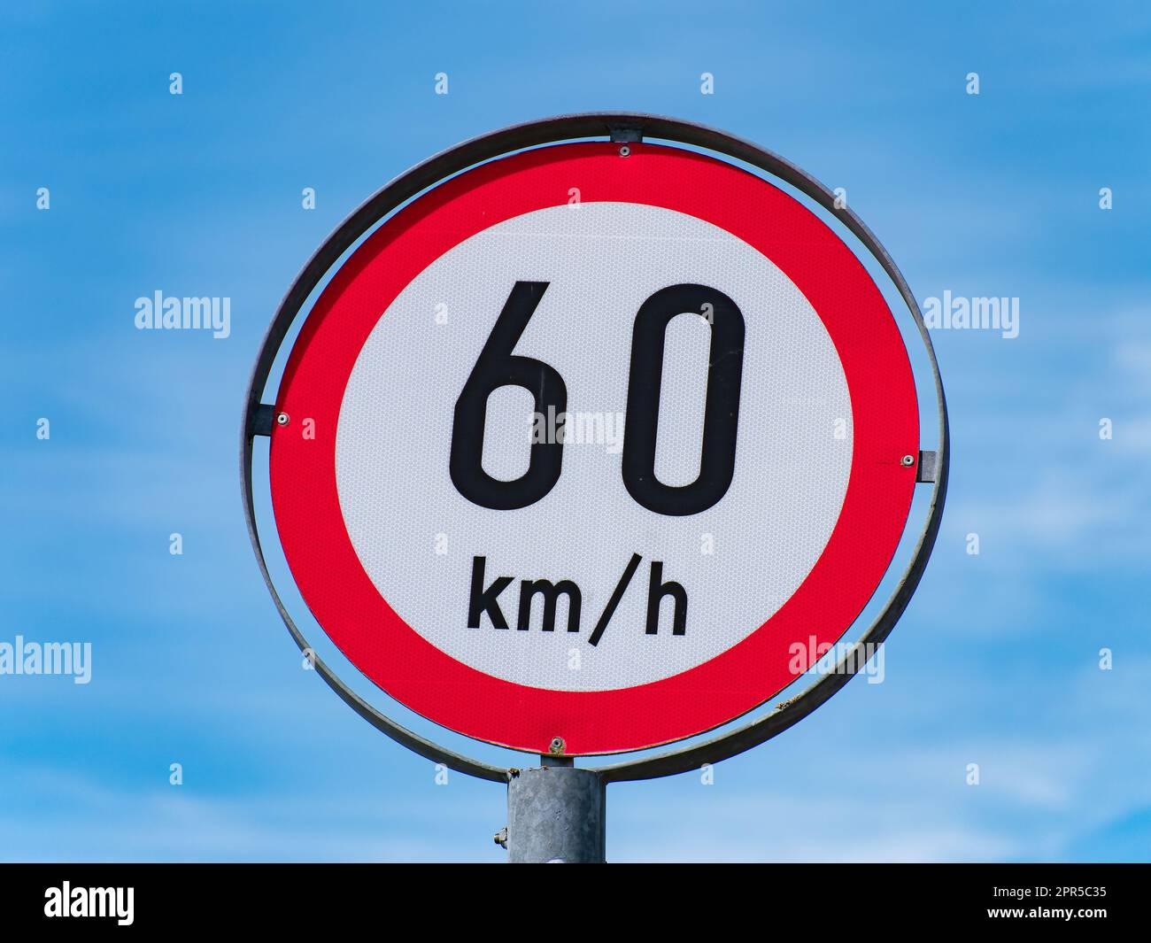 A road sign limiting the speed to 60 km h on a sky background. Stock Photo