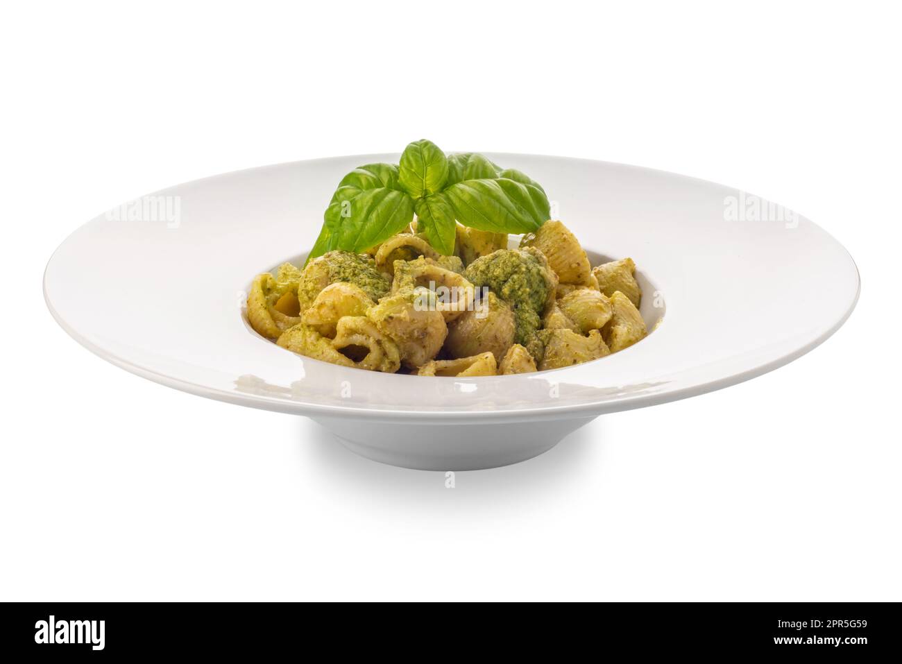 Macaroni pasta with pesto in a white dish with basil leaves, pesto is a typical Genoese sauce of basil, pine nuts, olive oil and parmesan cheese. Isol Stock Photo