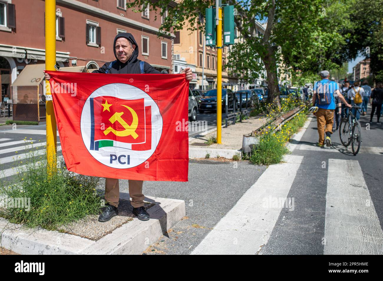 A stationary protester spreads the red flag of the Italian Communist Party during the demonstration. About 10 thousand demonstrators took part during the parade organized by the ANPI (National Association of Partisans of Italy) in Rome on the occasion of the 78th anniversary of the Liberation from Nazi-fascism. Starting from Largo Bompiani, they crossed the neighborhoods of Tor Marancia, Garbatella and Ostiense, until they arrived at Porta San Paolo. The demonstration ended in Piazzale Ostiense with speeches by political figures, trade unions and the testimonies of those who were partisans dur Stock Photo