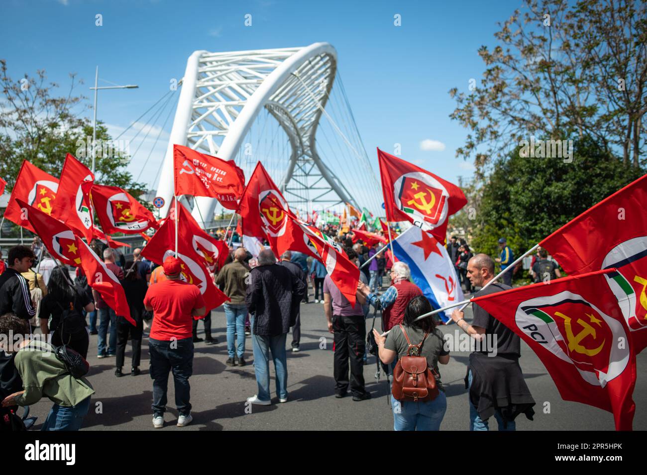 Protesters wave the red flags of the Italian Communist Party before crossing the Settimia Spizzichino bridge during the demonstration. About 10 thousand demonstrators took part during the parade organized by the ANPI (National Association of Partisans of Italy) in Rome on the occasion of the 78th anniversary of the Liberation from Nazi-fascism. Starting from Largo Bompiani, they crossed the neighborhoods of Tor Marancia, Garbatella and Ostiense, until they arrived at Porta San Paolo. The demonstration ended in Piazzale Ostiense with speeches by political figures, trade unions and the testimoni Stock Photo