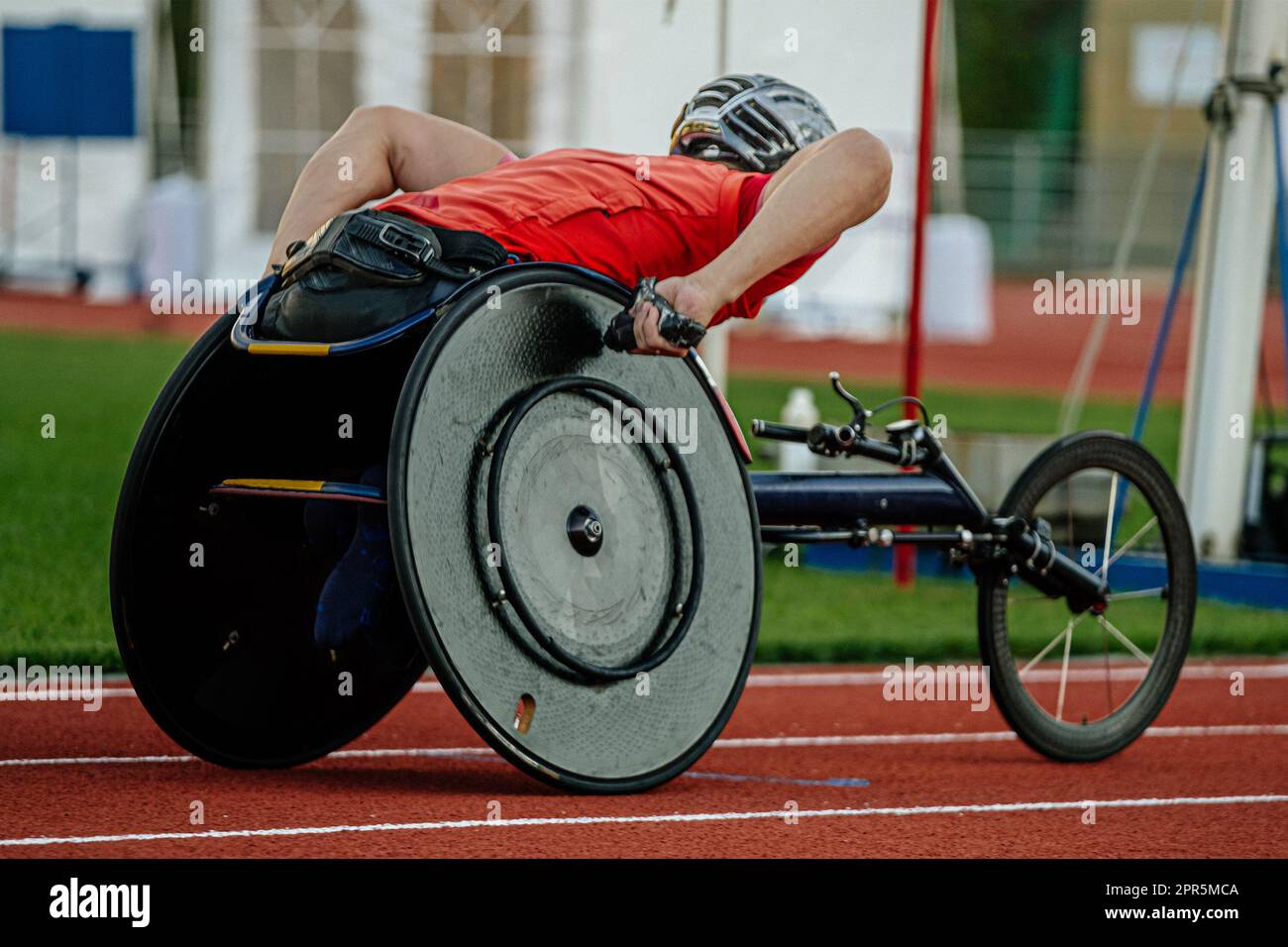 close-up para athlete in wheelchair racing riding on red track stadium, summer para athletics championships Stock Photo