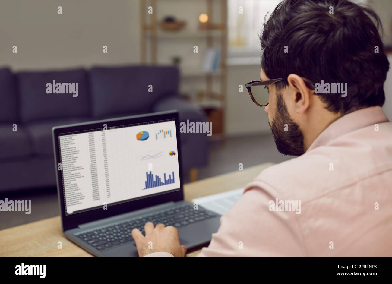 Focused businessman working with analytics using laptop sitting at workplace Stock Photo