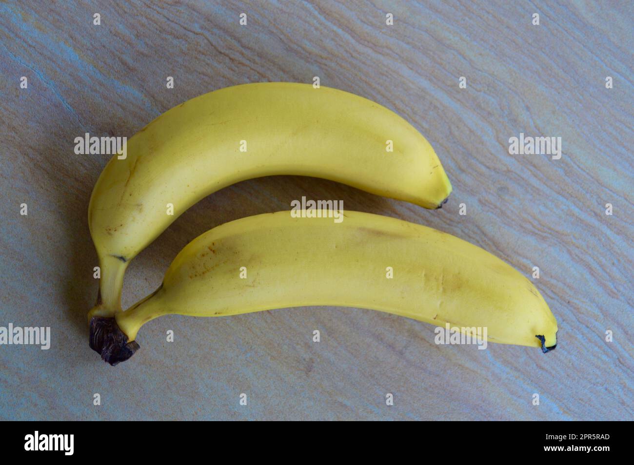 Two ripe bananas set out and ready to eat Stock Photo