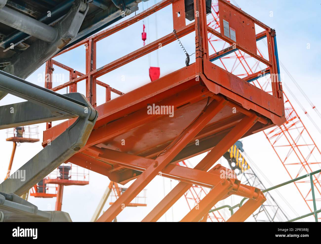 Articulated boom lift. Aerial platform lift. Telescopic boom lift against blue sky. Mobile construction crane for rent and sale. Maintenance and repair hydraulic boom lift service. Crane dealership. Stock Photo