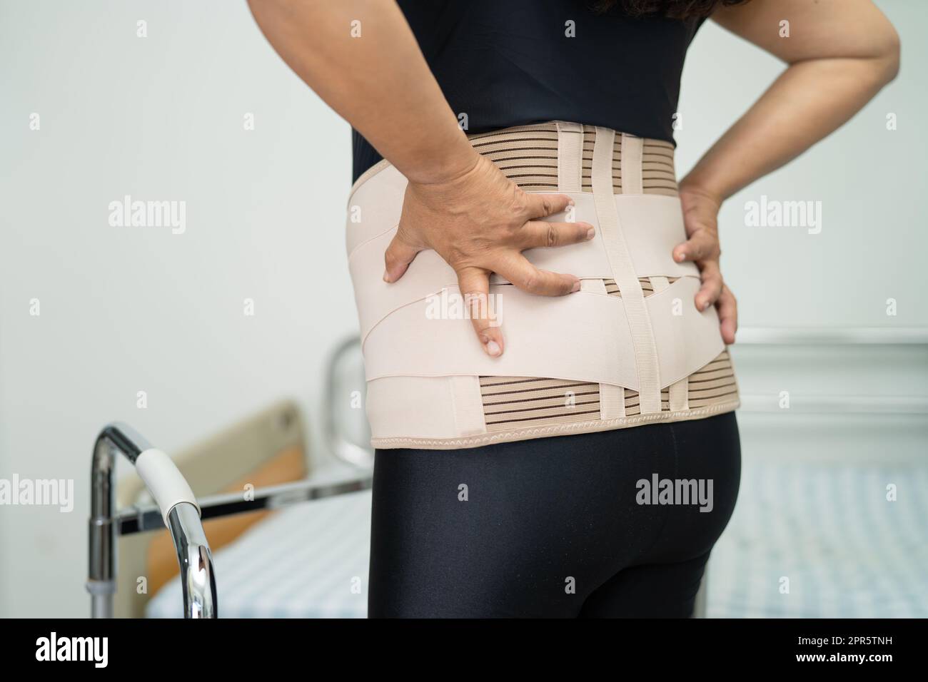 Asian lady patient wearing back pain support belt for orthopedic lumbar ...