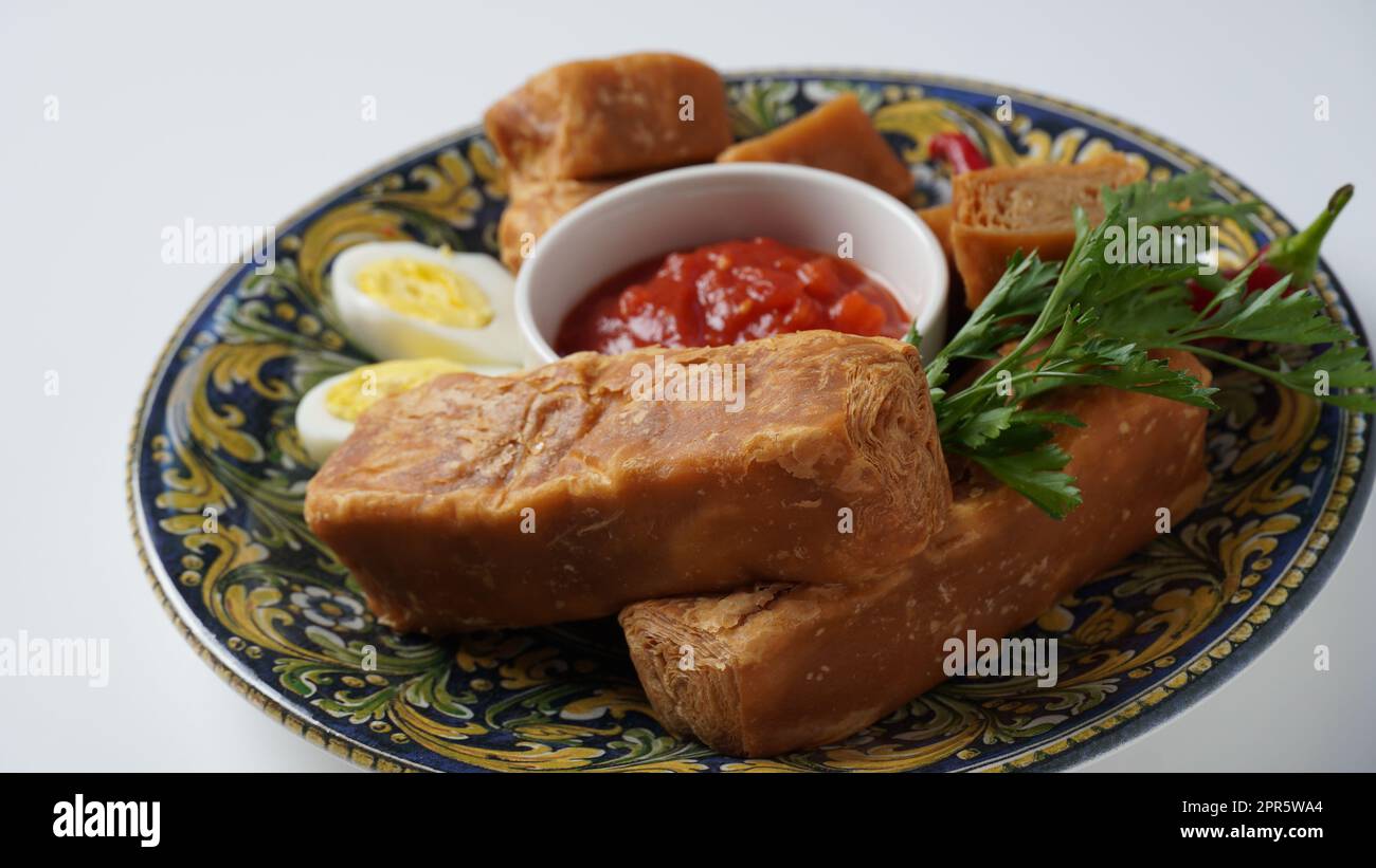 Jachnun or Jahnun, Yemenite Jewish pastry, served with fresh grated tomato and boiled egg and