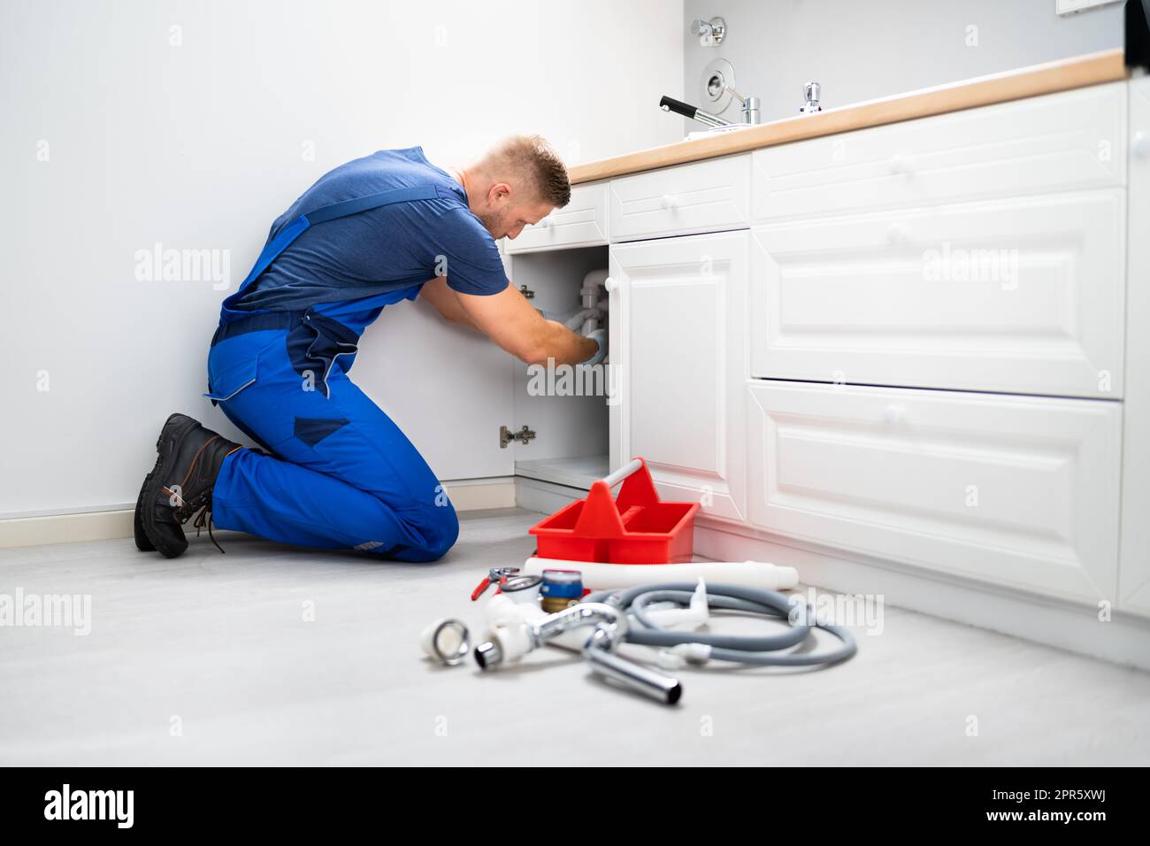 Male Plumber Fixing Sink Pipe Stock Photo