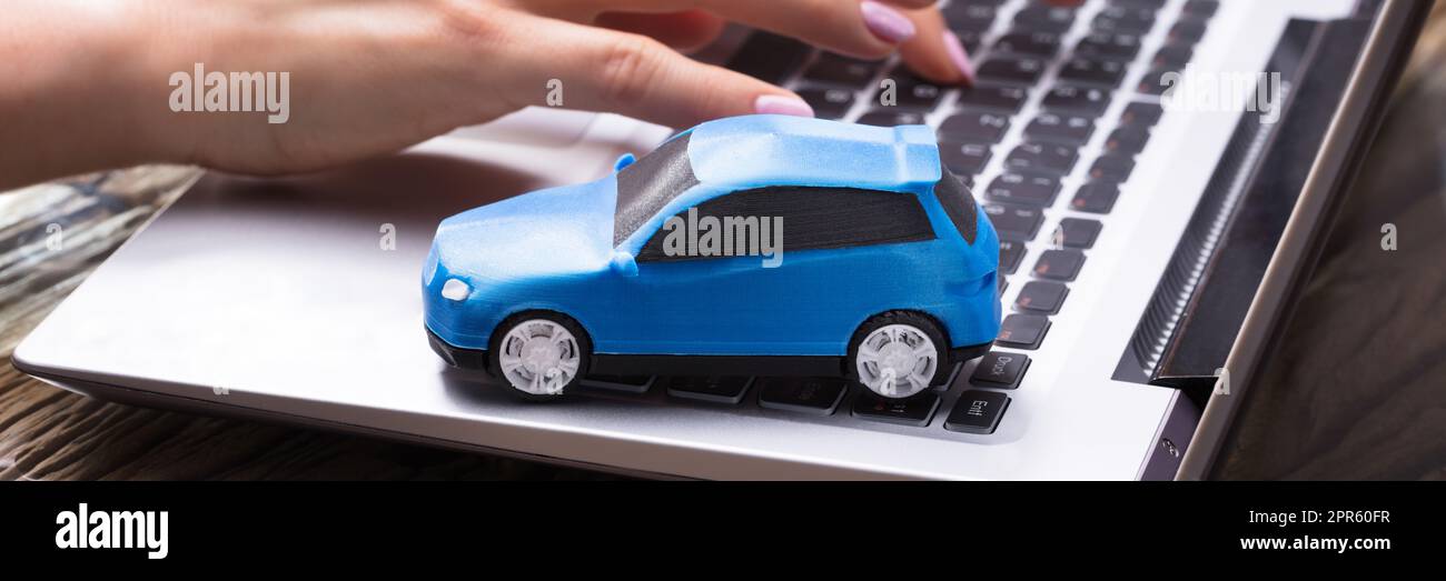 Small Blue Car On Laptop Keypad Stock Photo