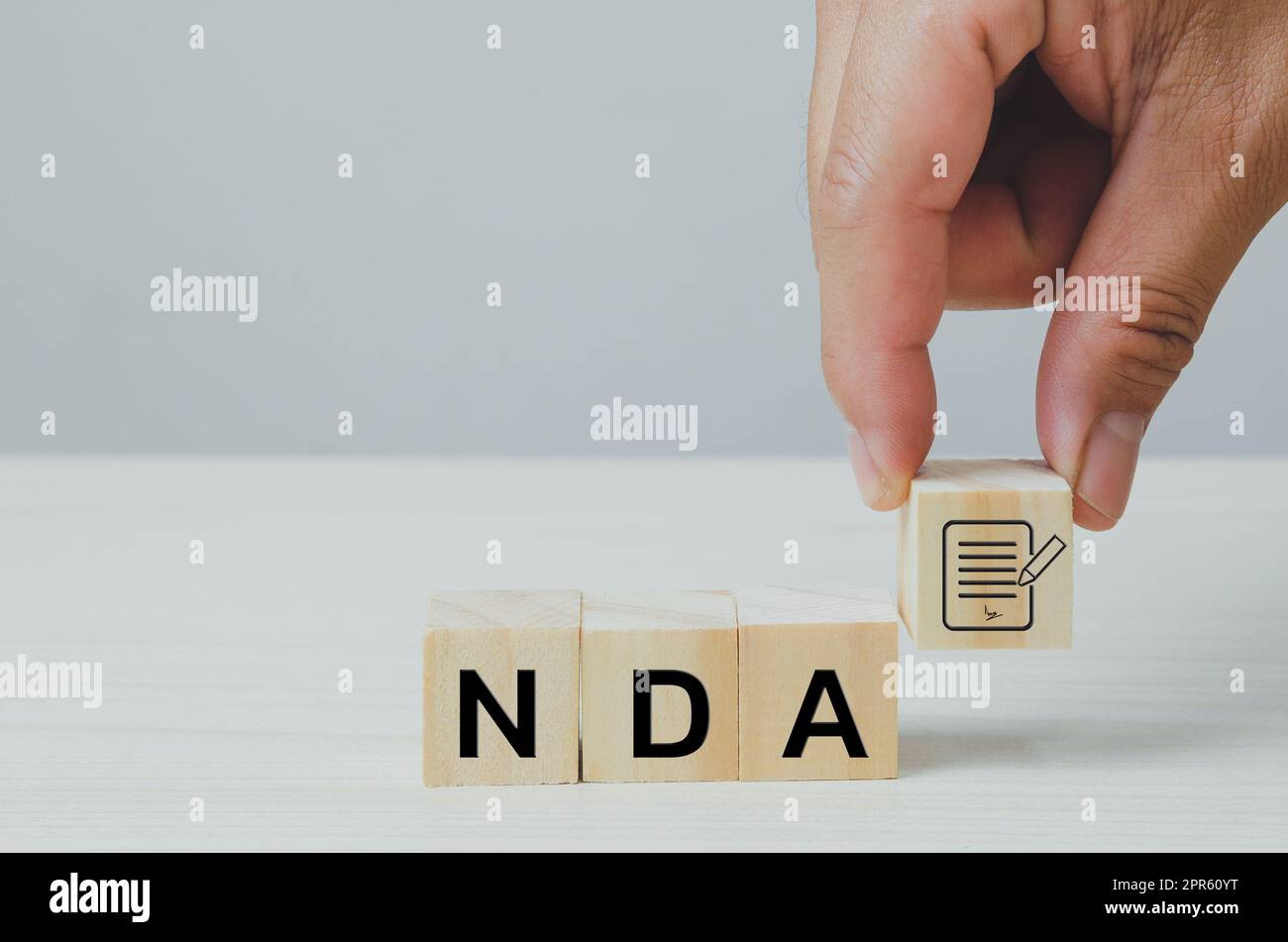Wooden cubes with NDA Non disclosure Agreement icon symbol background and copy space. Stock Photo