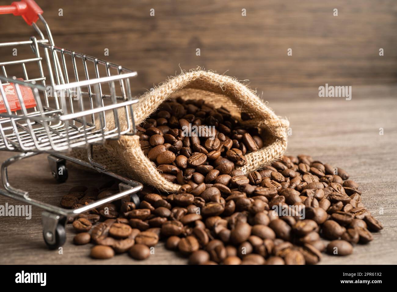Box with shopping cart on coffee beans, Import Export Shopping online or eCommerce delivery service store product shipping, trade, supplier concept. Stock Photo