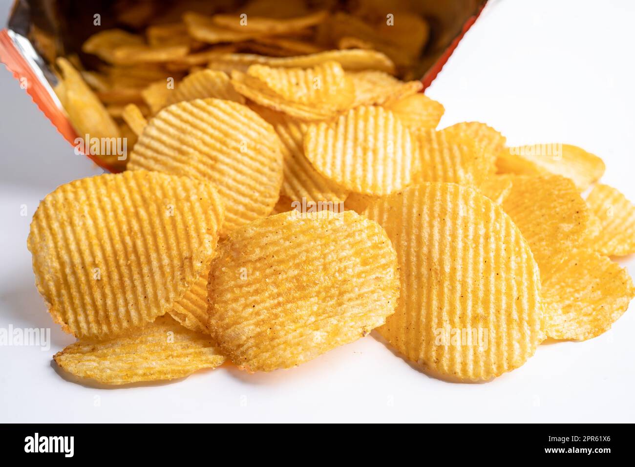 Potato chips, delicious BBQ seasoning spicy for crips, thin slice deep fried snack fast food in open bag. Stock Photo