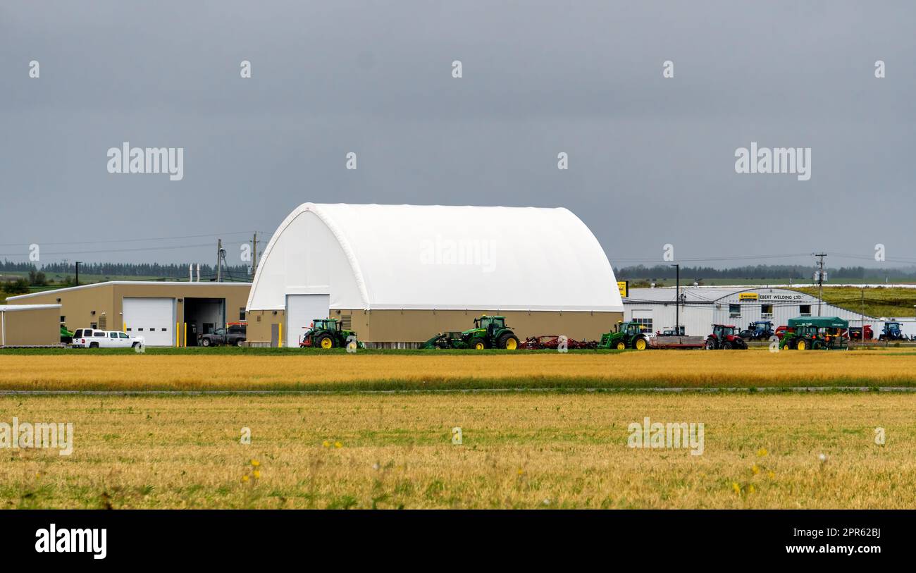Agricultural equipment repair company Ebert Welding Ltd., in New Liskeard, Temiskaming Shores, Ontario, Canada, with golden wheat fields in foreground Stock Photo