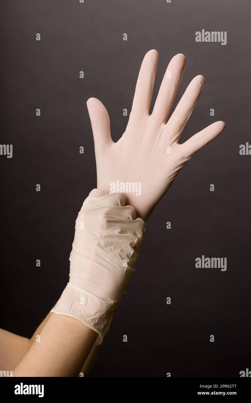 Doctor putting on latex gloves hi-res stock photography and images - Alamy
