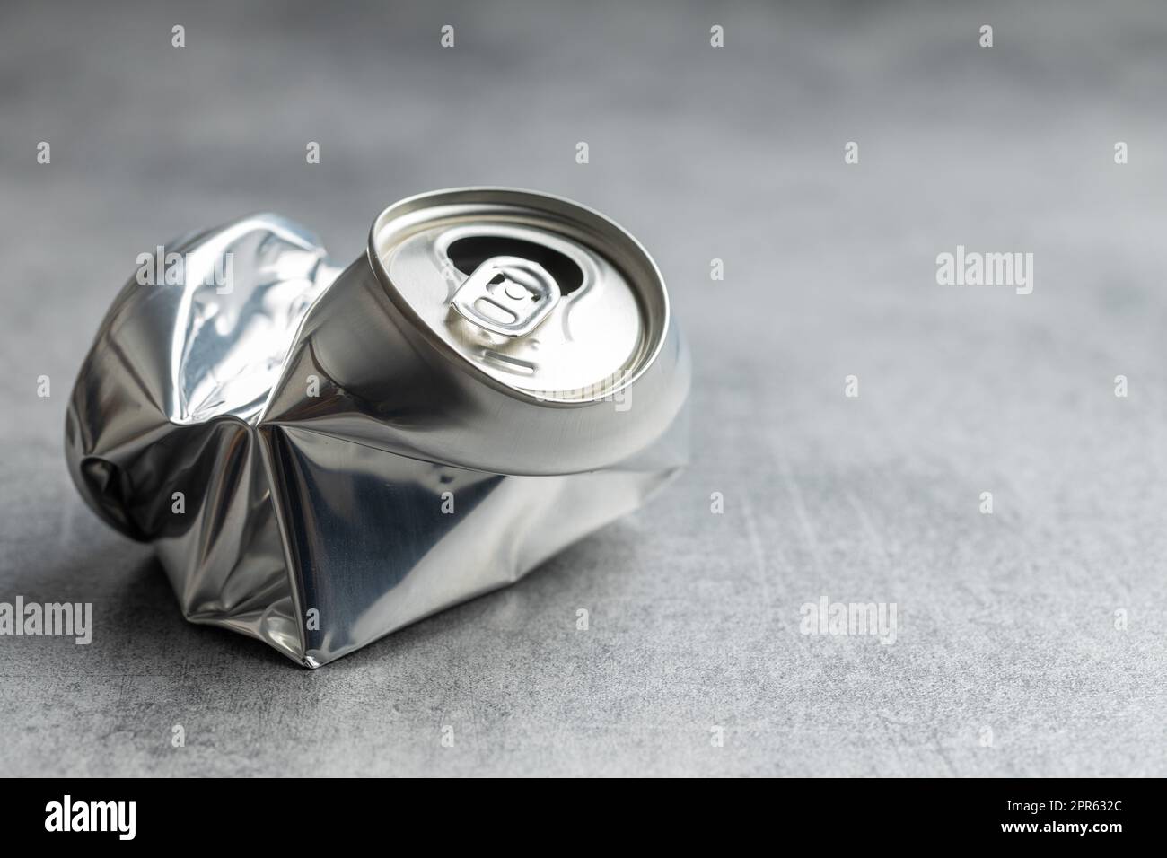 Empty crumpled can on gray table. Stock Photo