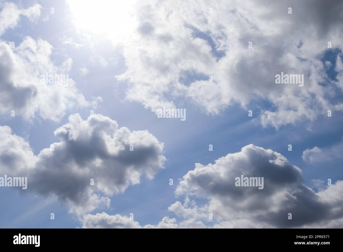 Beautiful view at sunbeams with some lens flares and clouds in a blue sky Stock Photo