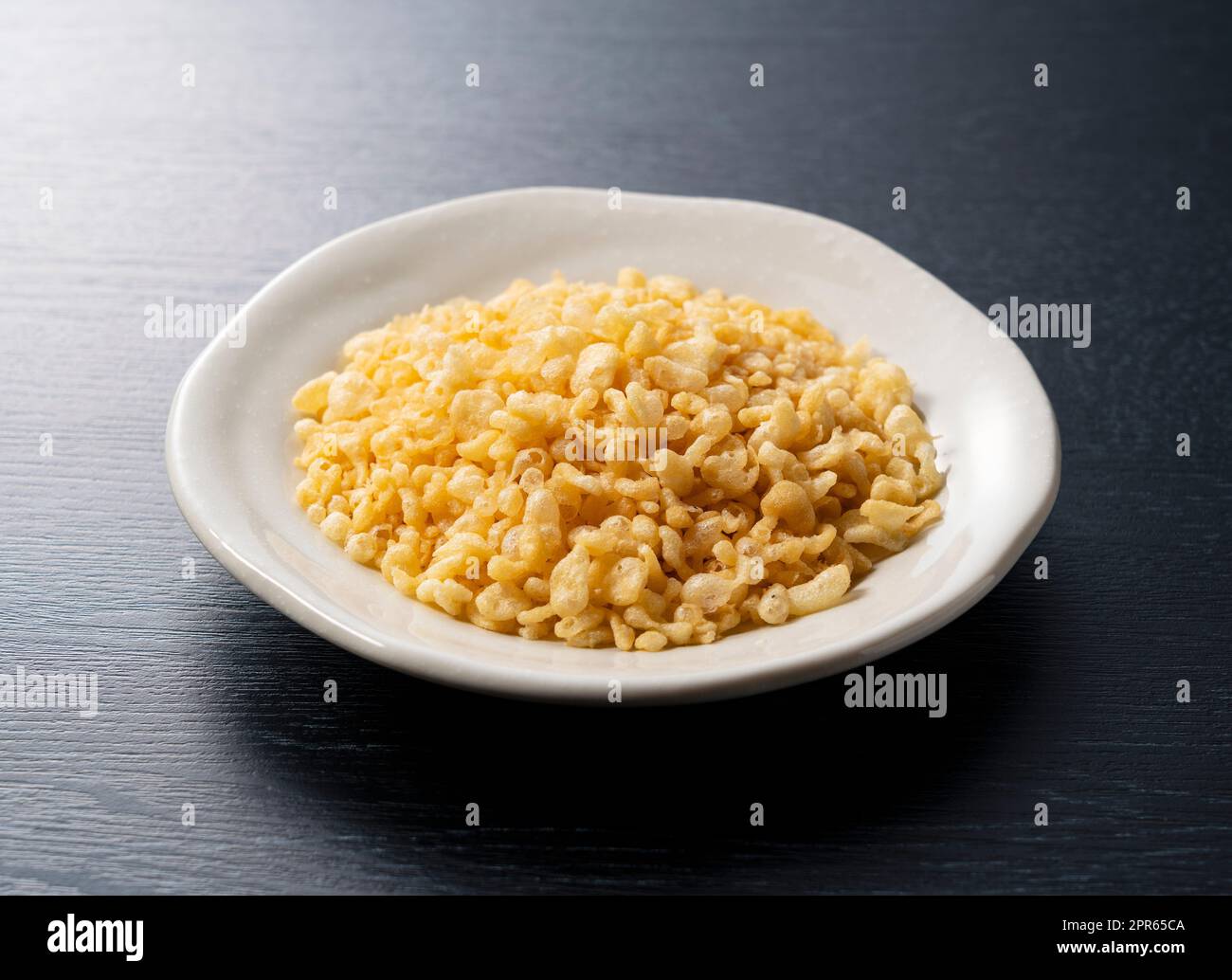 Tenkasu on a plate placed on a black background. Stock Photo