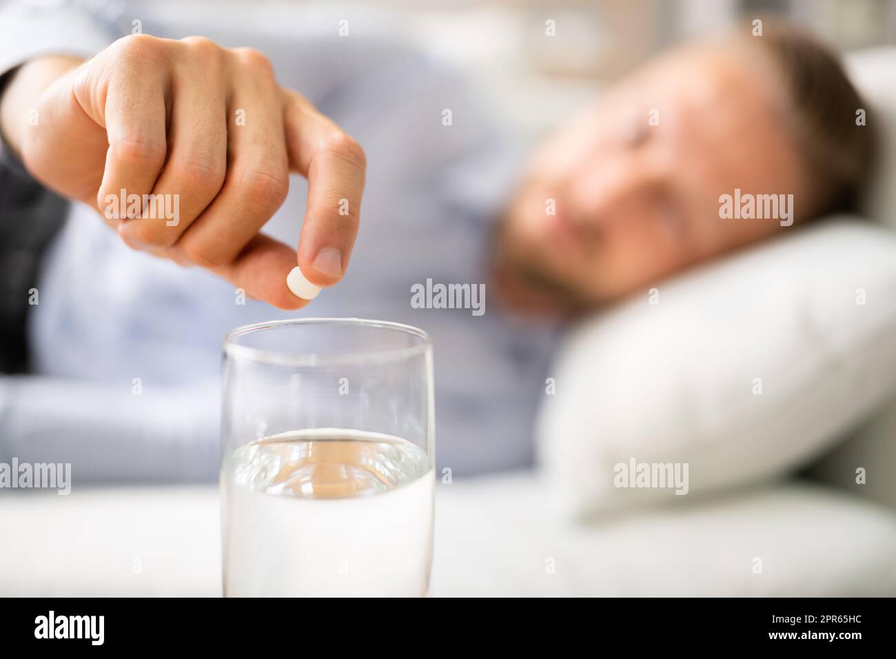 Man With Hangover Taking Medicine Pill Stock Photo