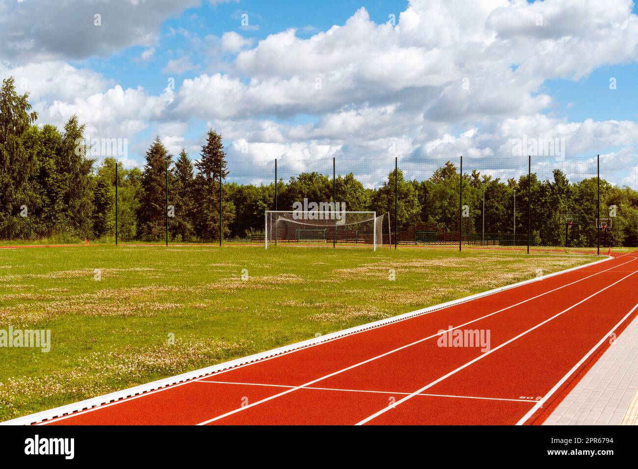 Empty school stadium with football gate and running track Stock Photo