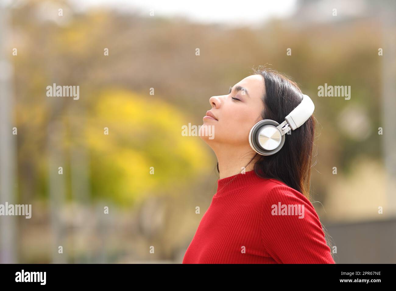 Woman in red wearing headphones meditating Stock Photo