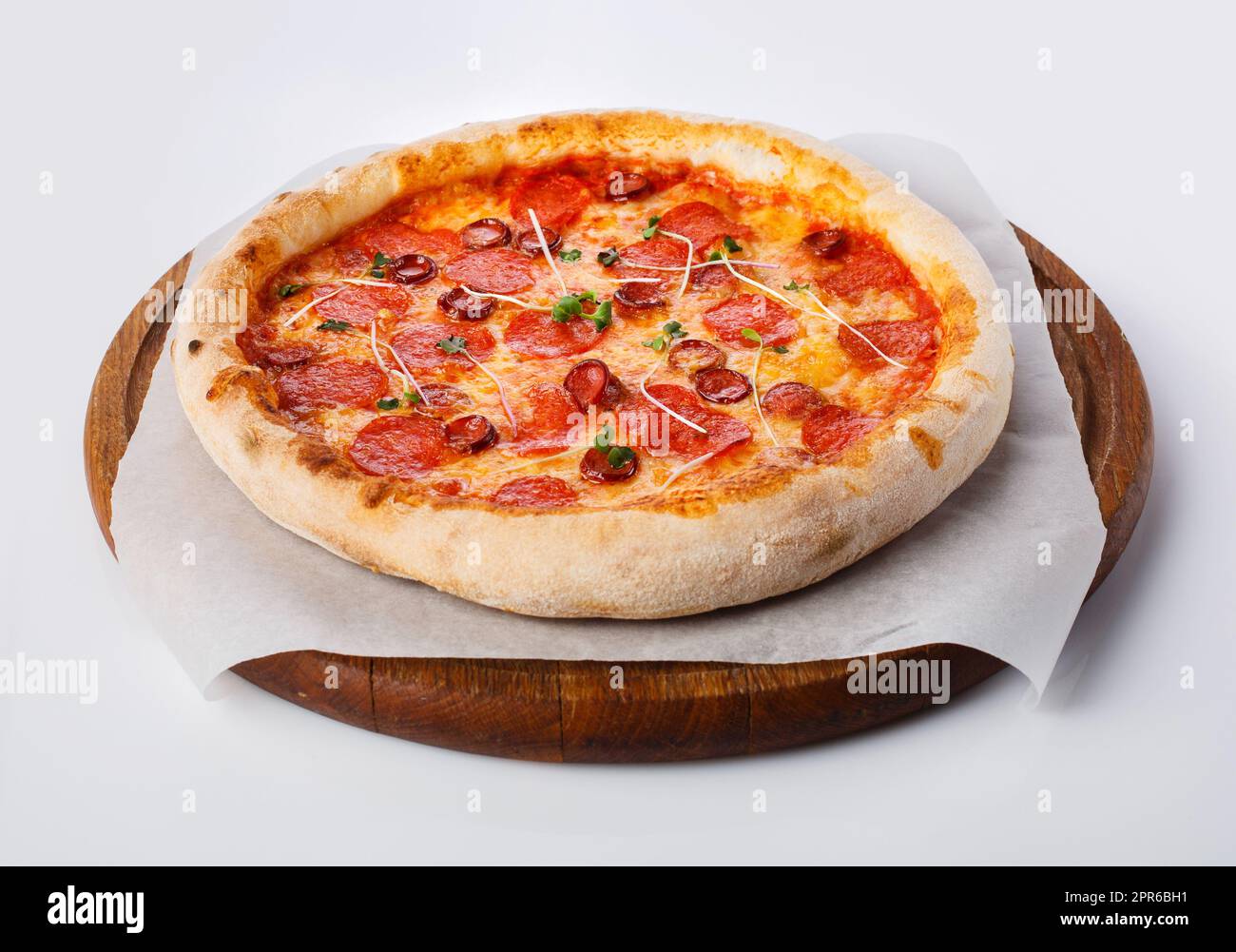 Top view of hot pizza on a wooden stand. Stock Photo