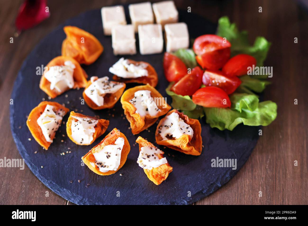 Hors d'oeuvre of dried persimmon and cream cheese for wine Stock Photo