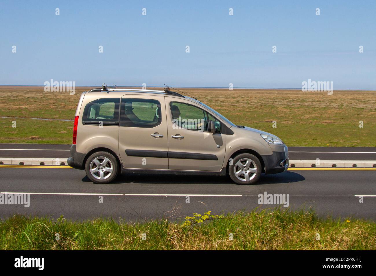 Side View of 2011 Peugeot Partner Tepee Outdoor Hdi 112 Beige Car Small MPV Diesel 1560 cc; travelling on the seafront Marine Drive, Southport, UK Stock Photo