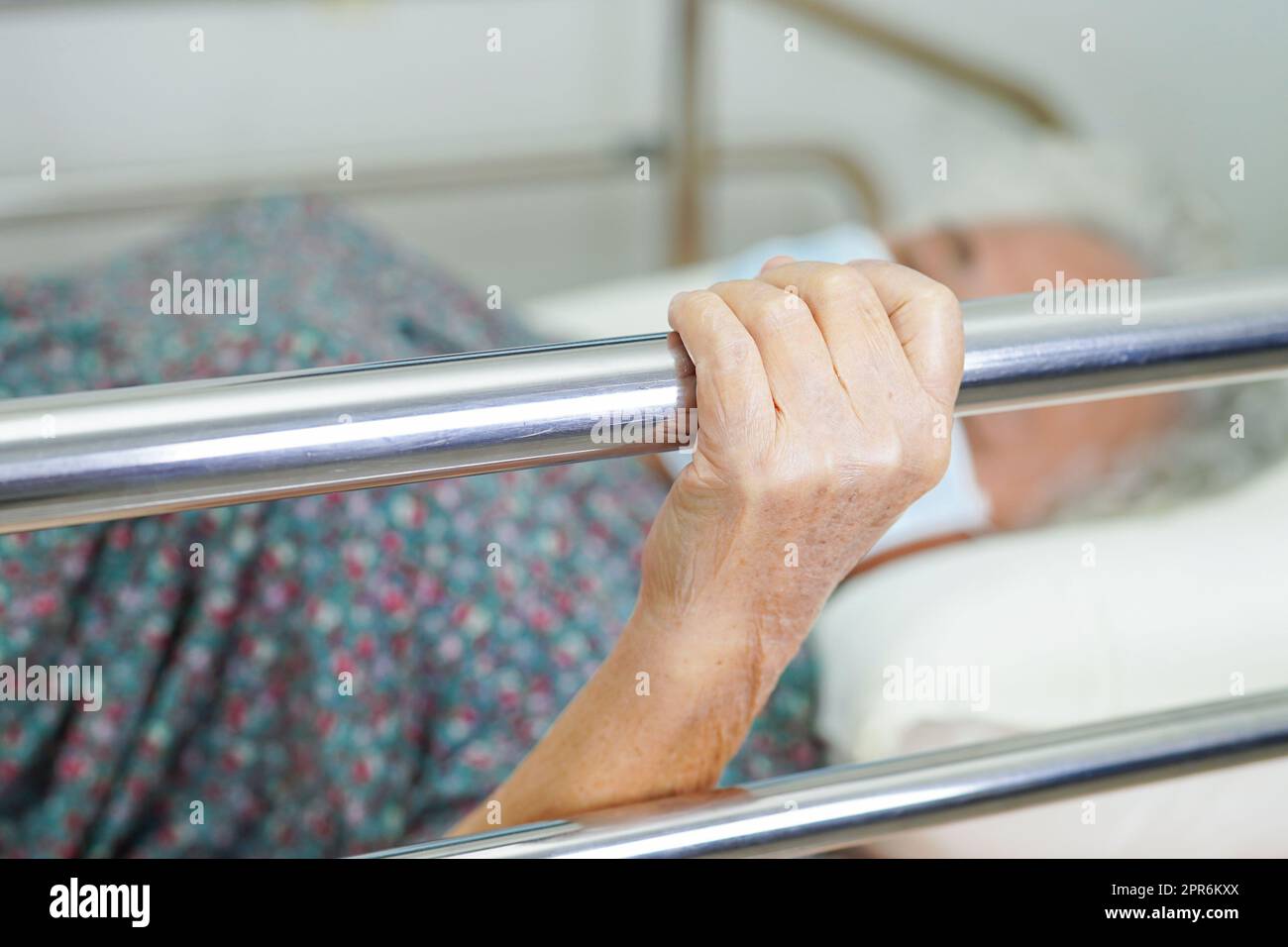 Asian Elder Senior Woman Patient Holding Bed Rail While Lie Down With ...