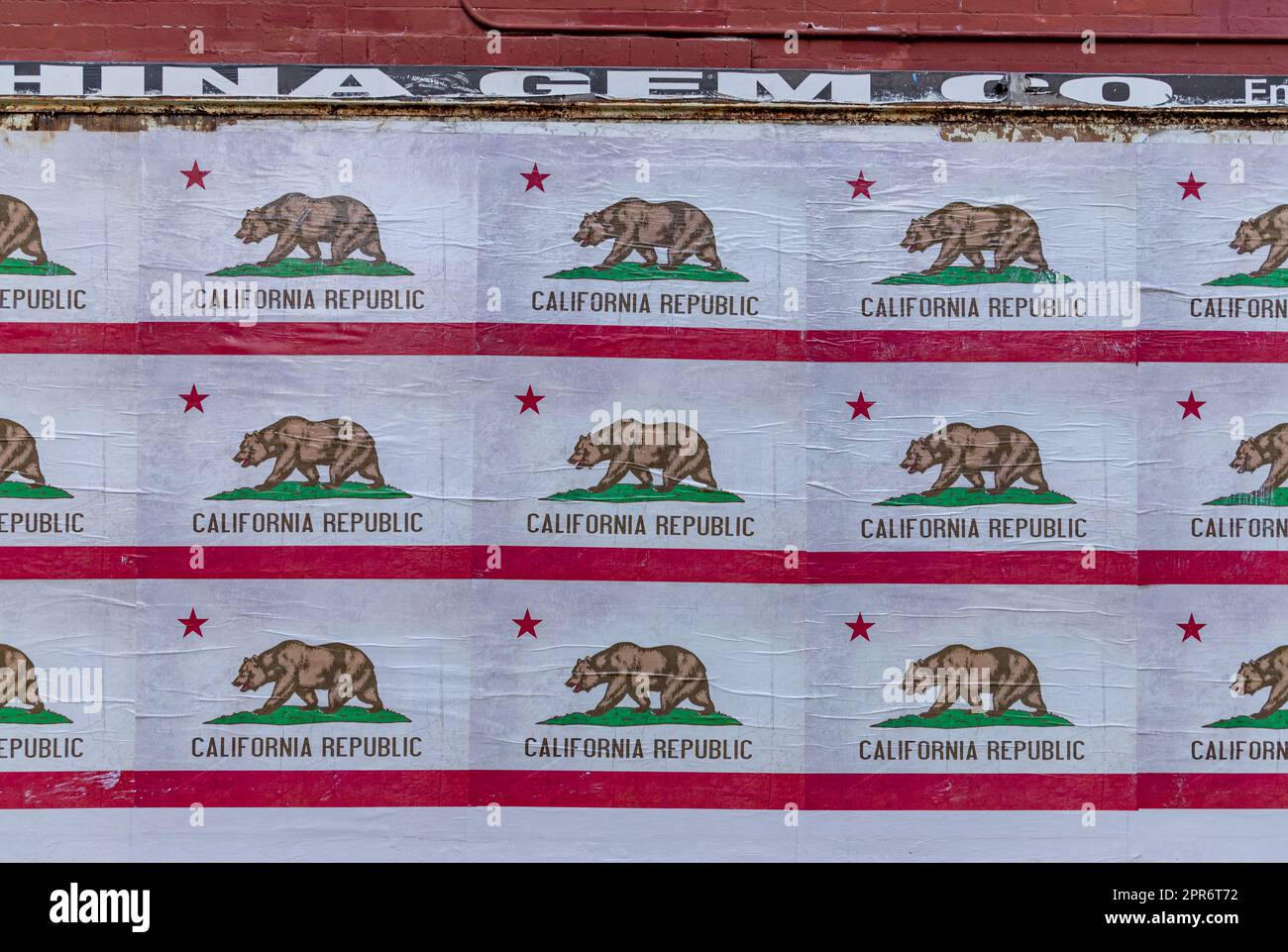 A picture of a wall with many California Republic flags posted on it. Stock Photo