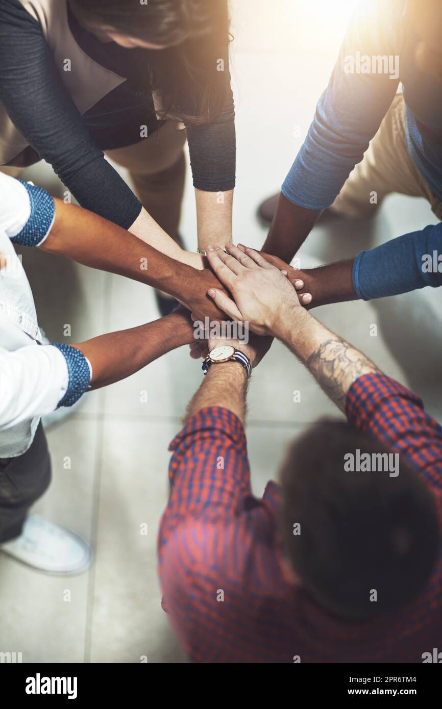 Taking it to the top together. Cropped shot of a work group joining hands in solidarity. Stock Photo