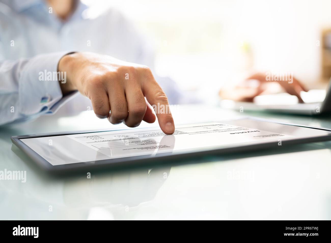 Businessperson Analyzing Invoice On Digital Tablet Stock Photo