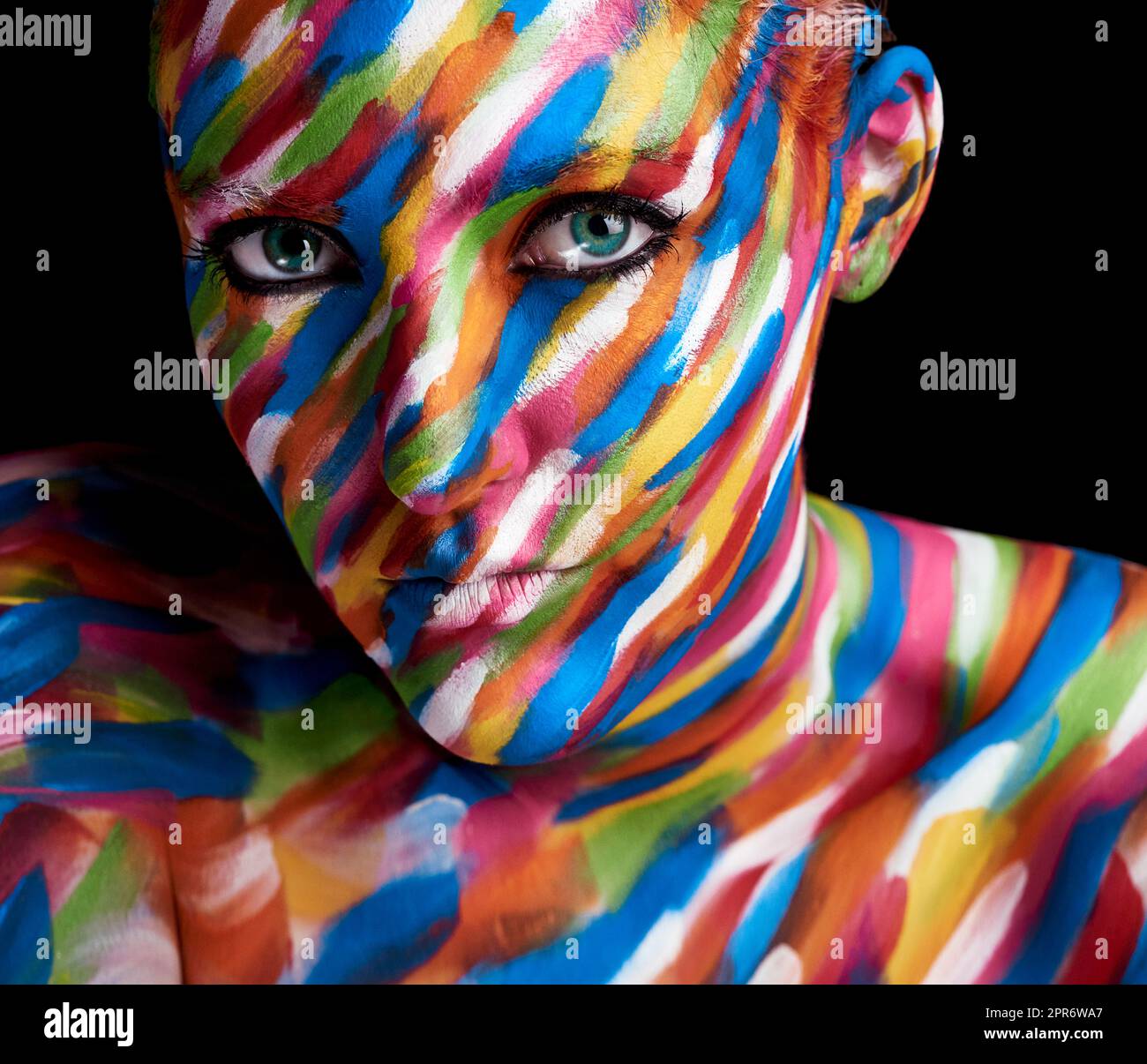 Clothed in colour. Cropped portrait of a young woman posing with paint on her face. Stock Photo