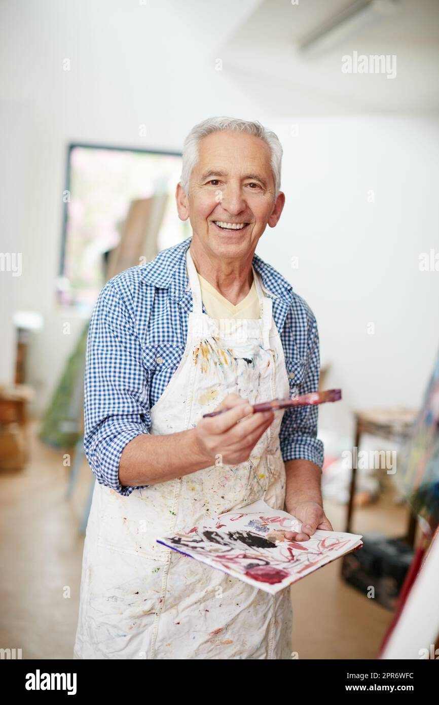 Painting is my hobby. Shot of a senior man working on a painting at home. Stock Photo